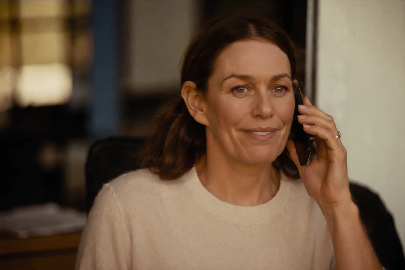 An owner taking a client call from her office, unhurried.